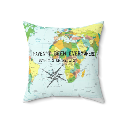 A throw pillow featuring the travel quote "I haven't been everywhere but it's on my list" with a compass rose and world map design.