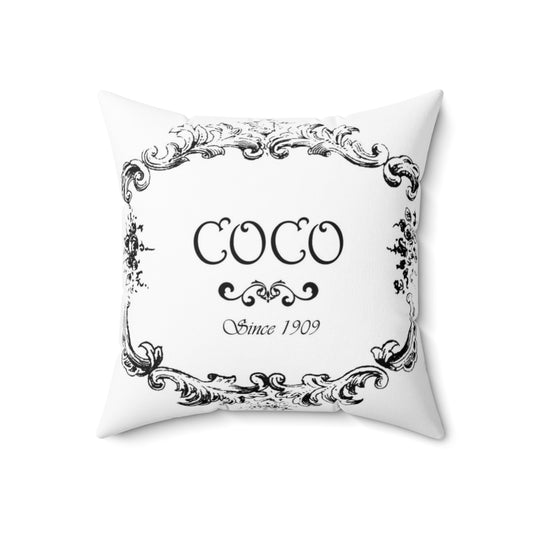 Vintage-style decorative pillow featuring a faded coco logo design in pink, turquoise, and purple