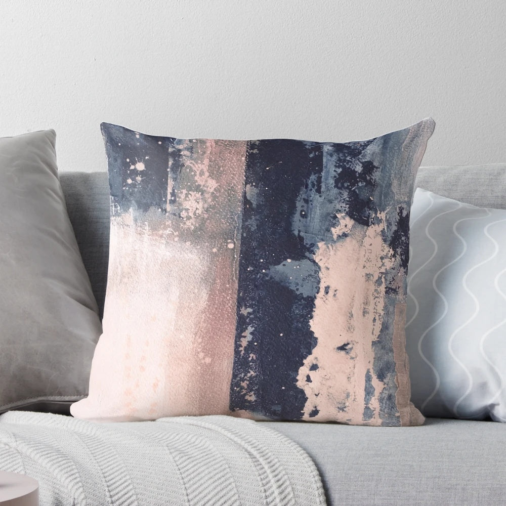 Horizontal abstract art pillow in shades of blush pink and navy blue, featuring brushstrokes and a modern, industrial-style design.