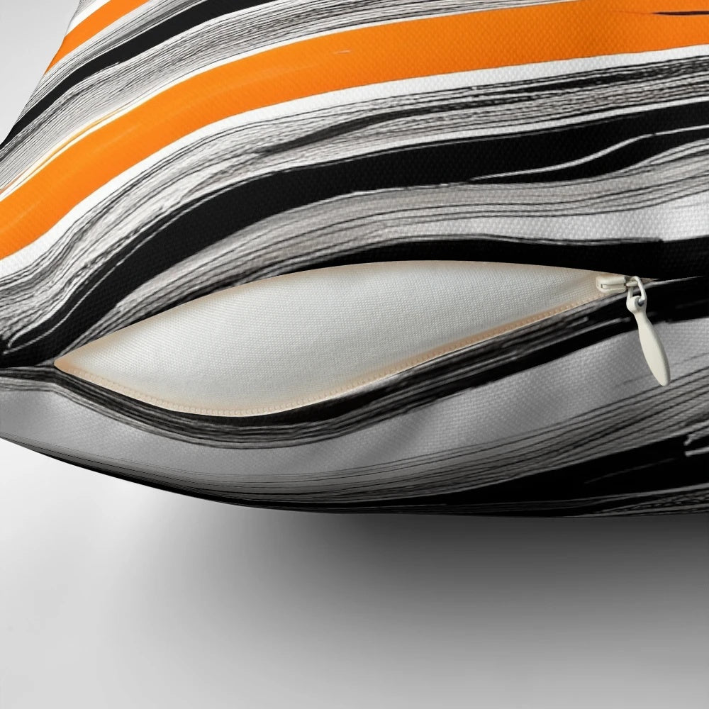 An abstract, circular pattern decorative pillow in shades of orange, gray, and black with paint brush strokes.
