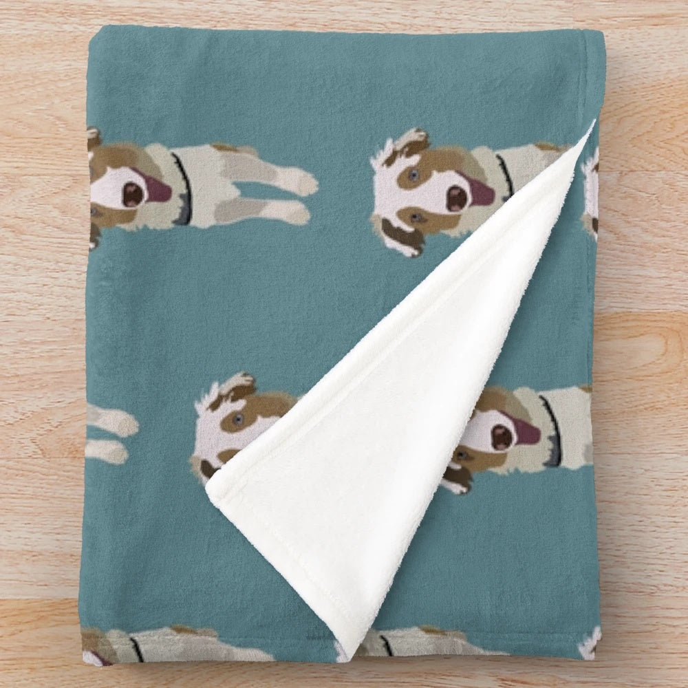 Australian Shepherd puppy snuggling in soft, plush blanket
