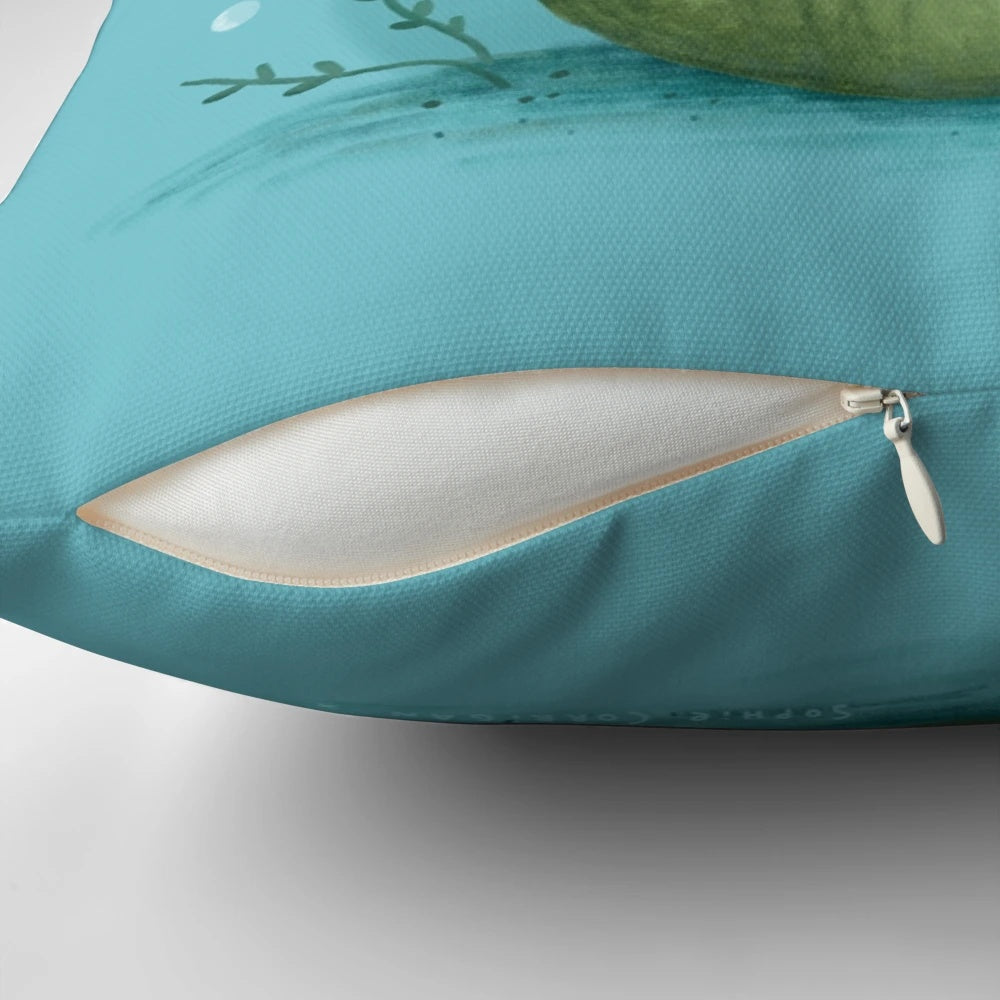 Photograph of a cute, leucistic axolotl sitting on a green, moss-covered ball-shaped pillow