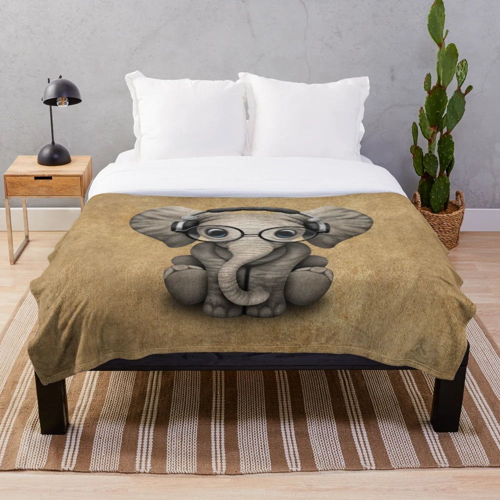 Cute baby elephant wearing headphones and glasses on a soft, cozy plush blanket
