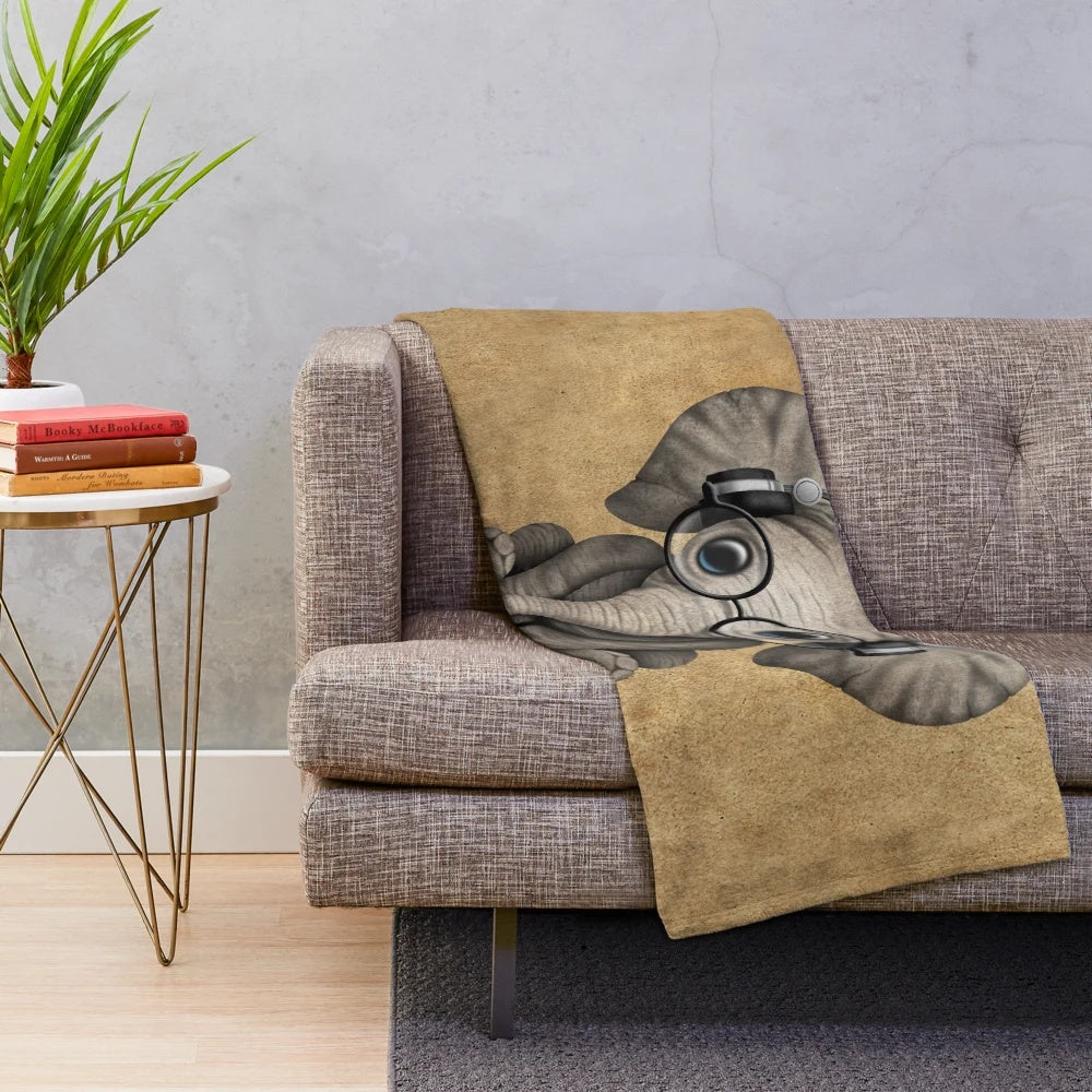 Cute baby elephant wearing headphones and glasses on a soft, cozy plush blanket