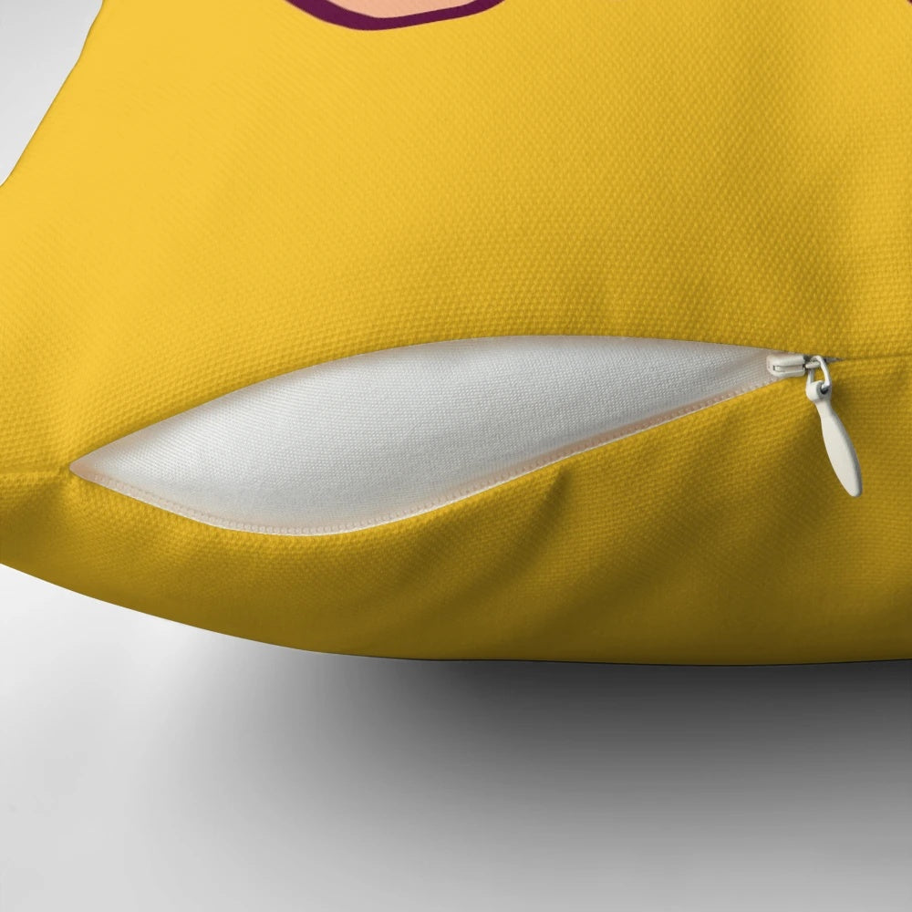Closeup of a soft, plush pillow in the shape of a cute, chibi-style banana-colored pig.