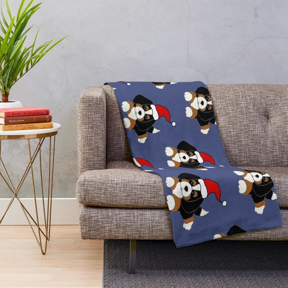 Cute Bernese Mountain Dog wearing a Santa hat on a cozy plush blanket