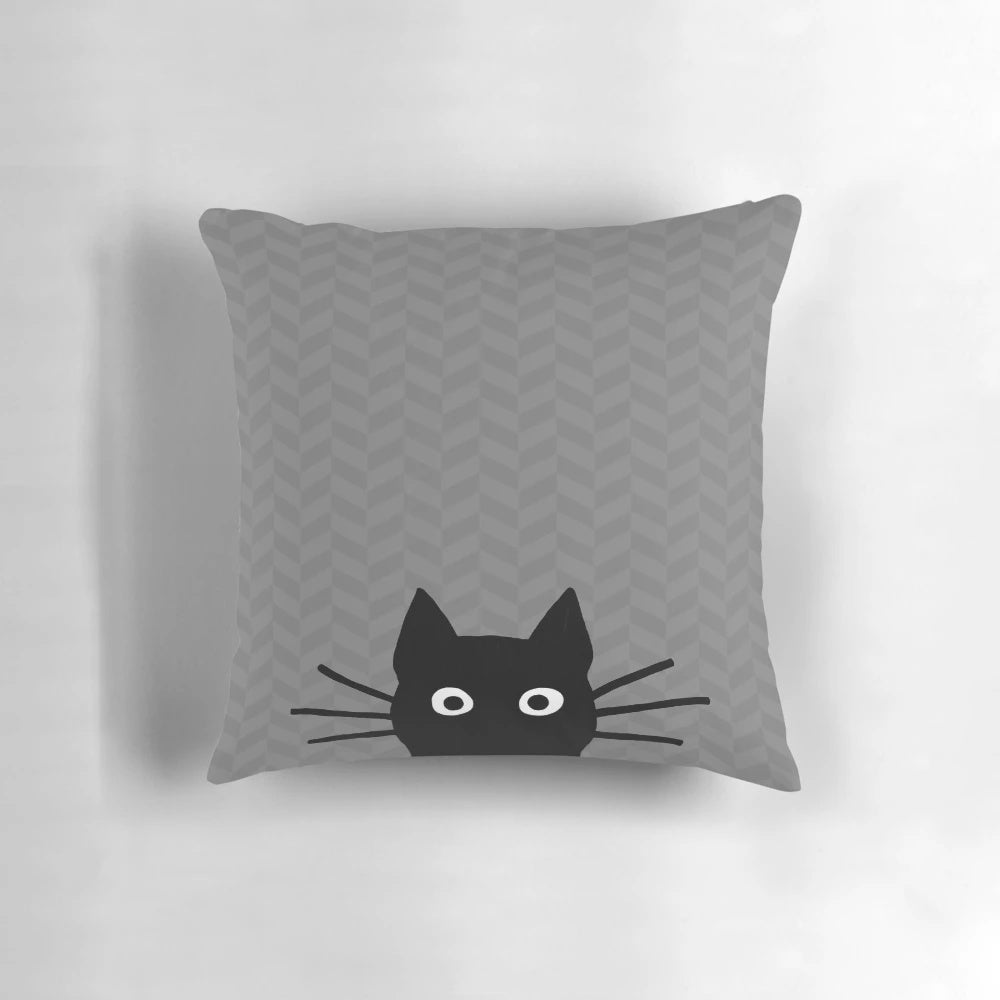 A soft, plush pillow featuring the charming face of a black cat with whiskers.