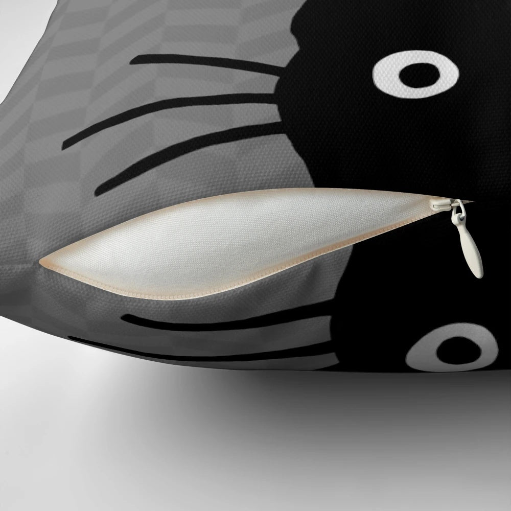 A soft, plush pillow featuring the charming face of a black cat with whiskers.