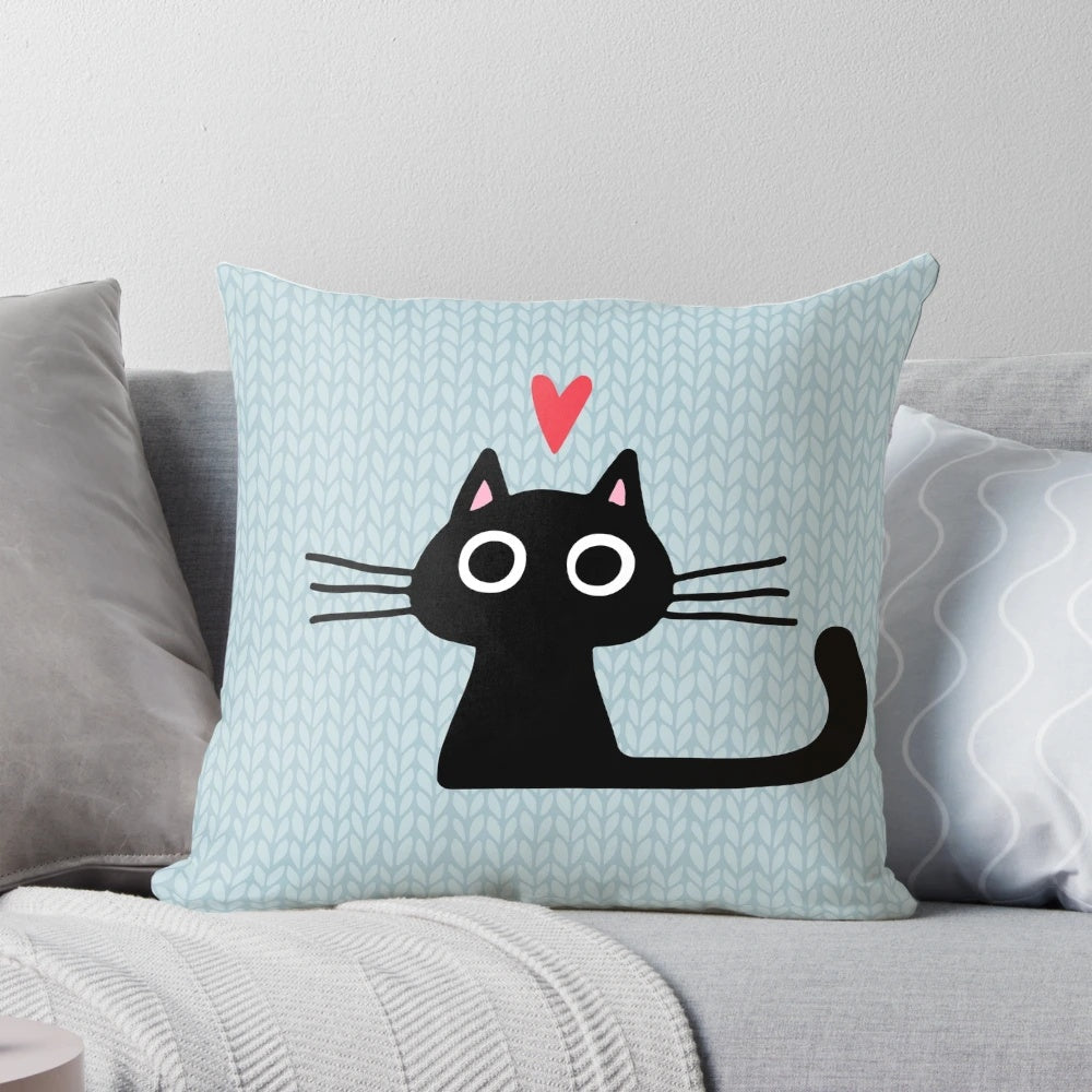 Soft, heart-shaped pillow featuring an illustration of a cute black cat kitten for Valentine's Day