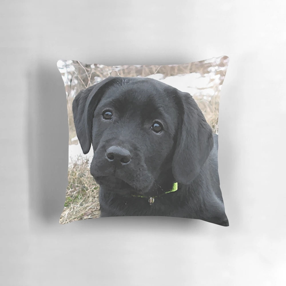 Black labrador puppy resting on a decorative pillow