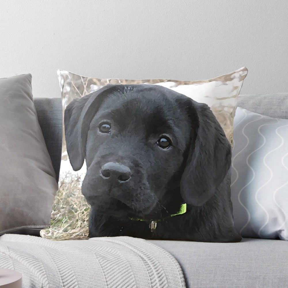 Black labrador puppy resting on a decorative pillow