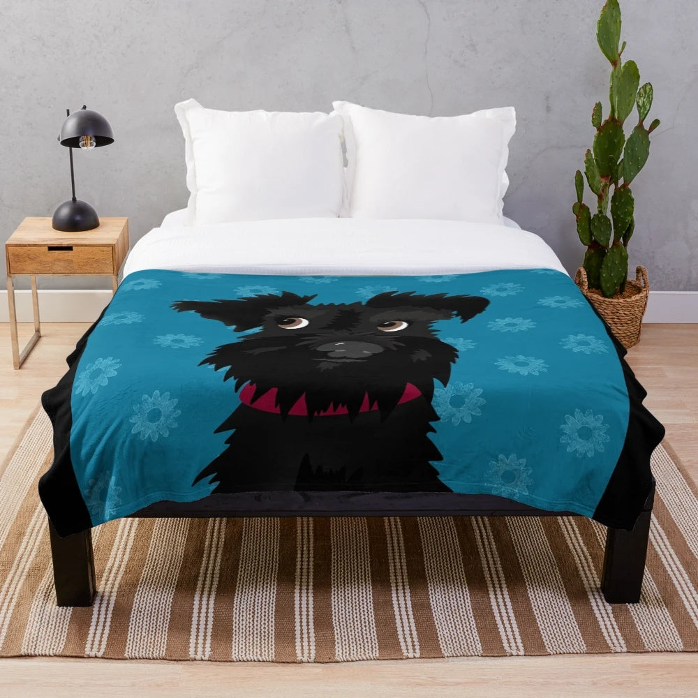 Black miniature schnauzer dog with blue daisies on a plush blanket