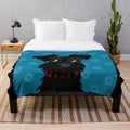 Black miniature schnauzer dog with blue daisies on a plush blanket