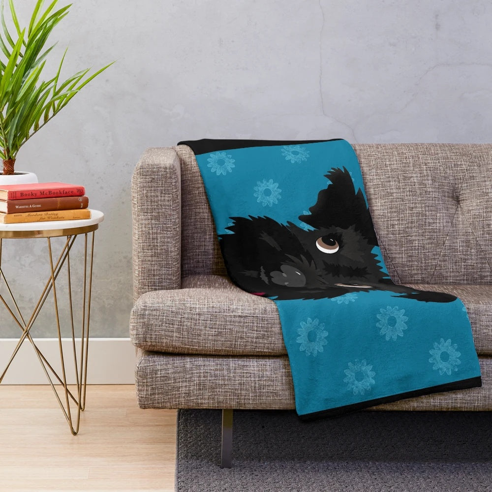 Black miniature schnauzer dog with blue daisies on a plush blanket