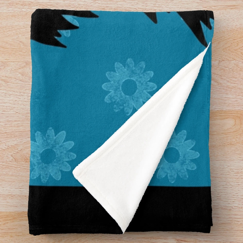 Black miniature schnauzer dog with blue daisies on a plush blanket