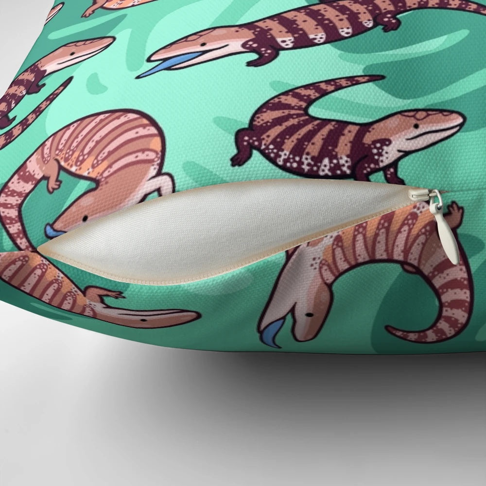 A vibrant and whimsical throw pillow featuring a playful cartoon illustration of a blue tongue skink.