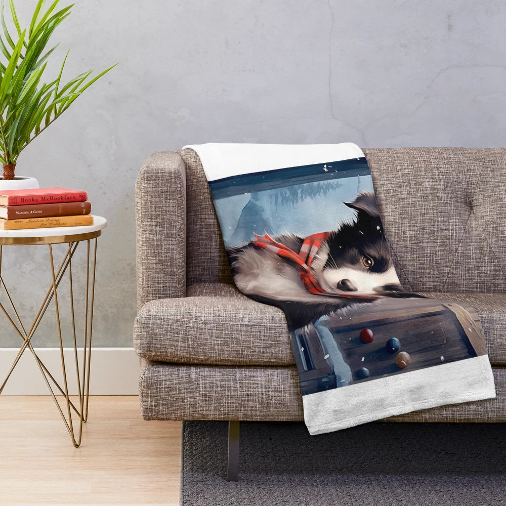 Cute border collie puppy in a snowy winter scene on a soft plush blanket