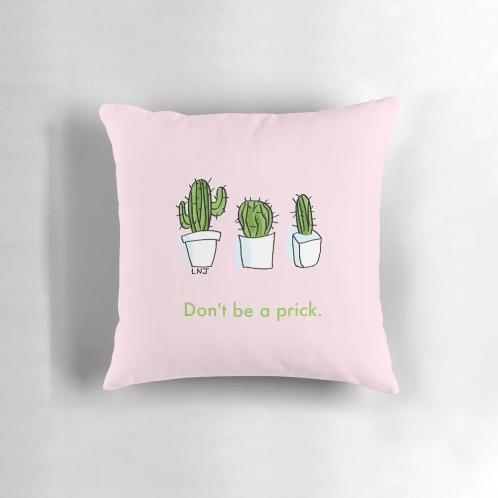 Three pink and green smol cartoon cactus plants on a decorative throw pillow