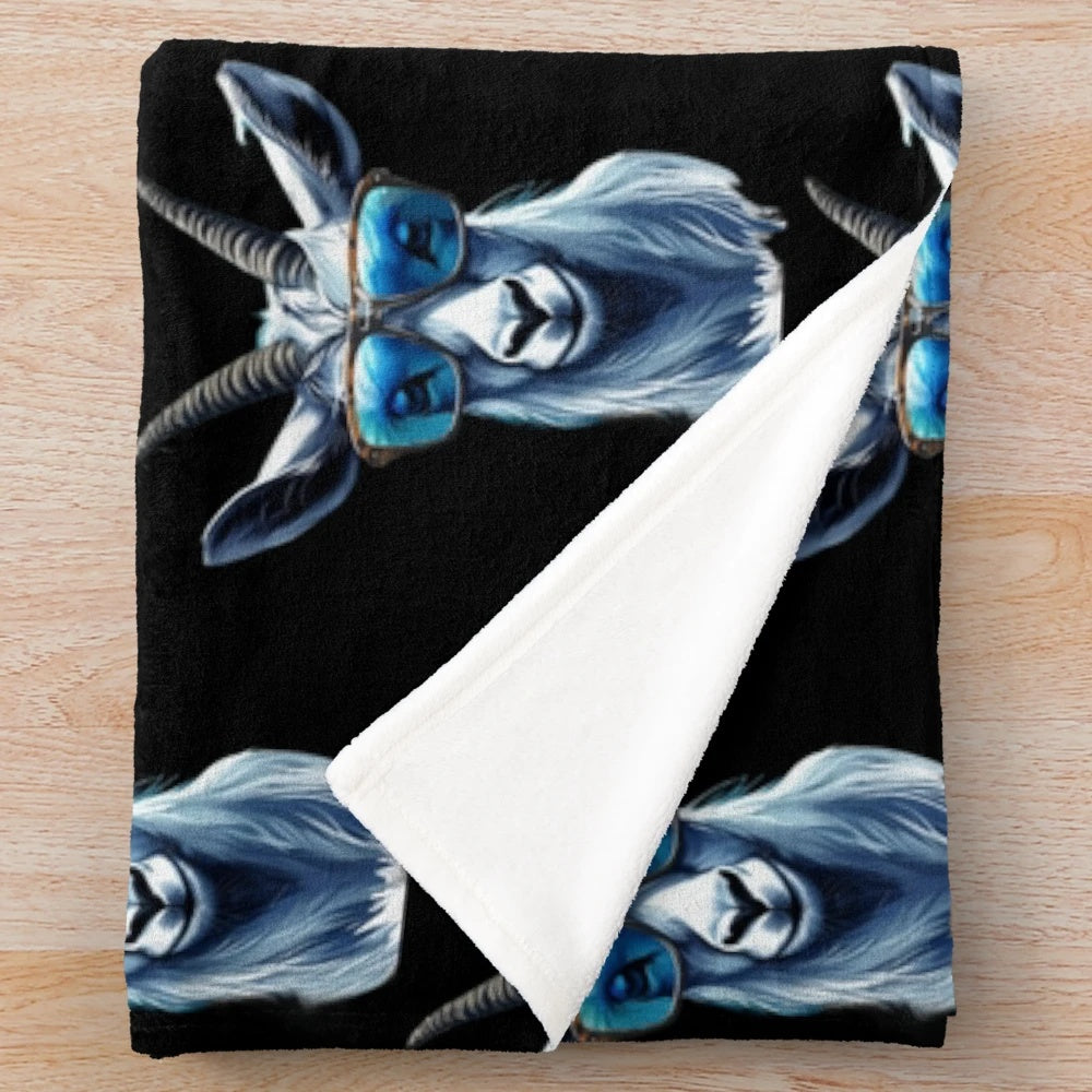 Cute cat wearing blue sunglasses on a cozy plush blanket