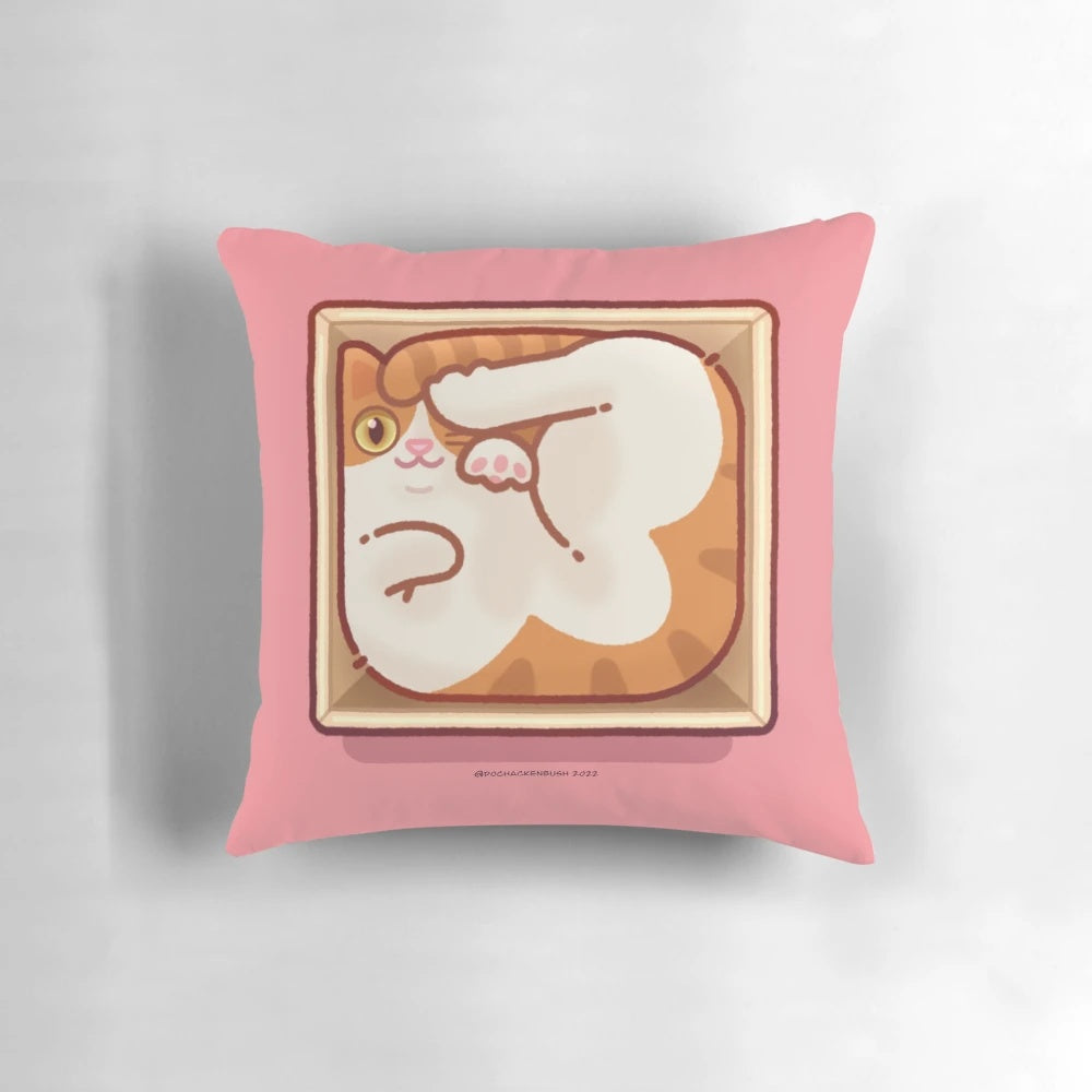 A square-shaped pillow with a cute cat peeking out of a box.