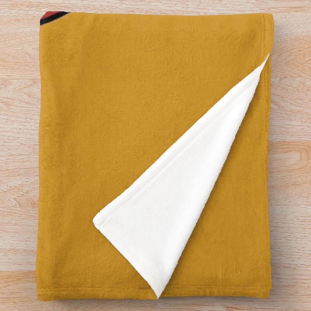 A cozy plush blanket featuring a cute cat peeking out of a pumpkin design