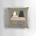 A decorative throw pillow featuring an illustration of various colorful cats in a cardboard box.