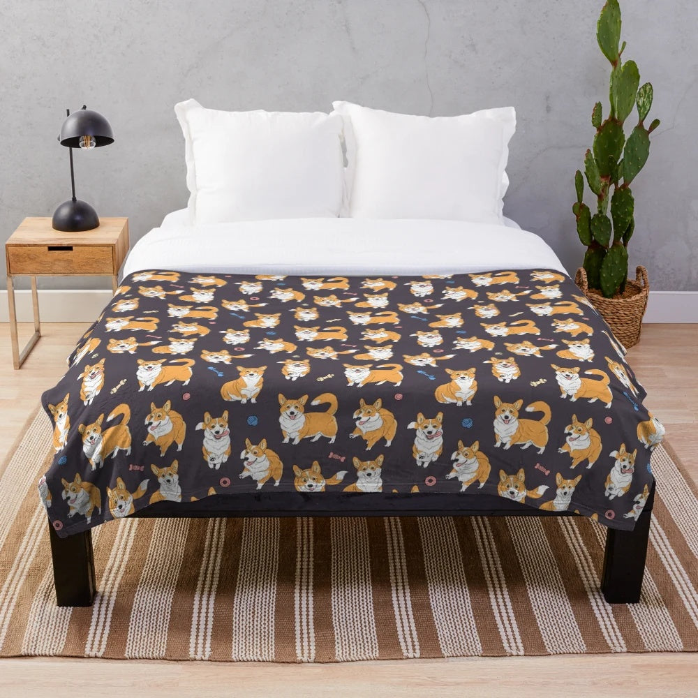 Cute Corgis playing on a grey plush blanket