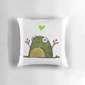 A green, heart-shaped pillow featuring a cute frog design, perfect for adding a touch of whimsy to any room.