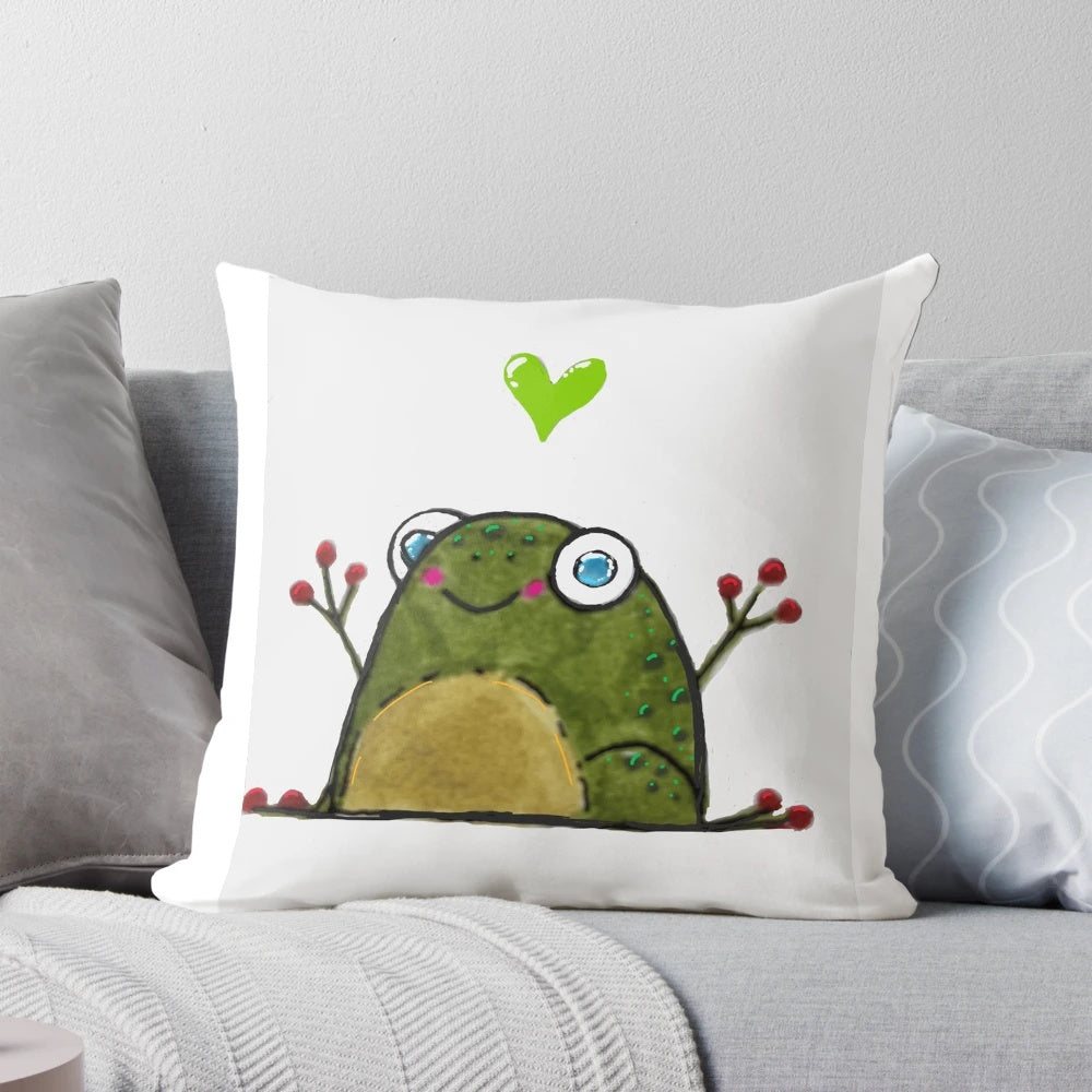 A green, heart-shaped pillow featuring a cute frog design, perfect for adding a touch of whimsy to any room.