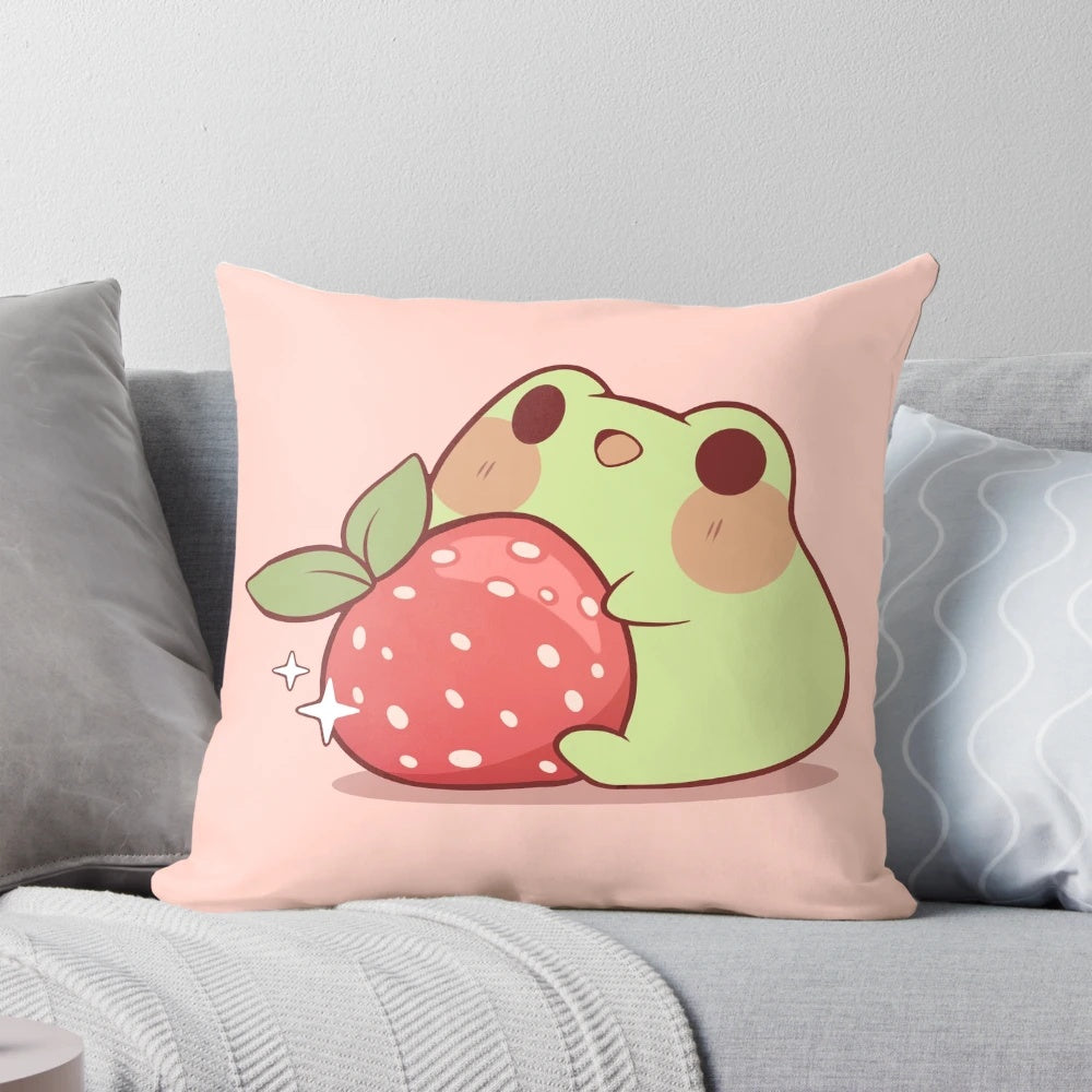 Soft, plush pillow featuring a cute, kawaii-style frog sitting on a strawberry against a pastel, cottagecore-inspired background