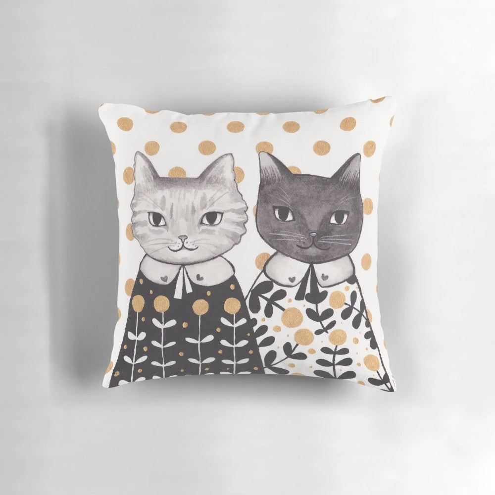Colorful kitten pillow with capes in a floral pattern.