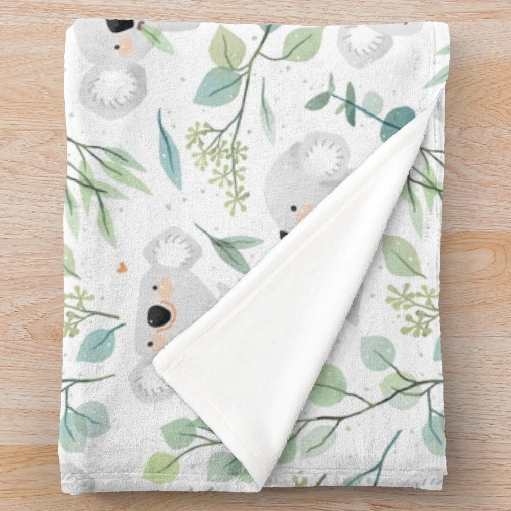 Soft and cuddly koala plush blanket with a whimsical eucalyptus leaf pattern