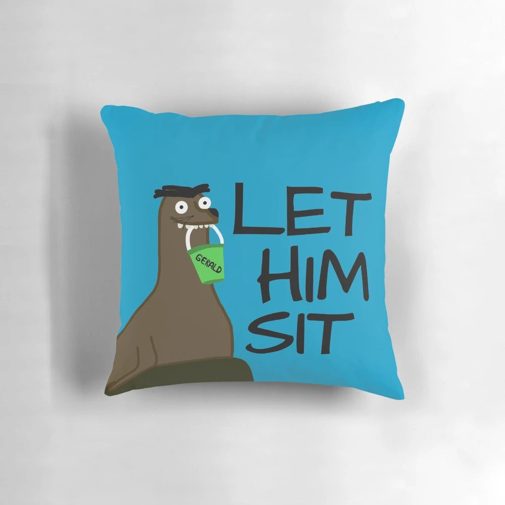 Photograph of a plush, decorative pillow shaped like a sea lion, with the text "Let Gerald Sit" printed on it.