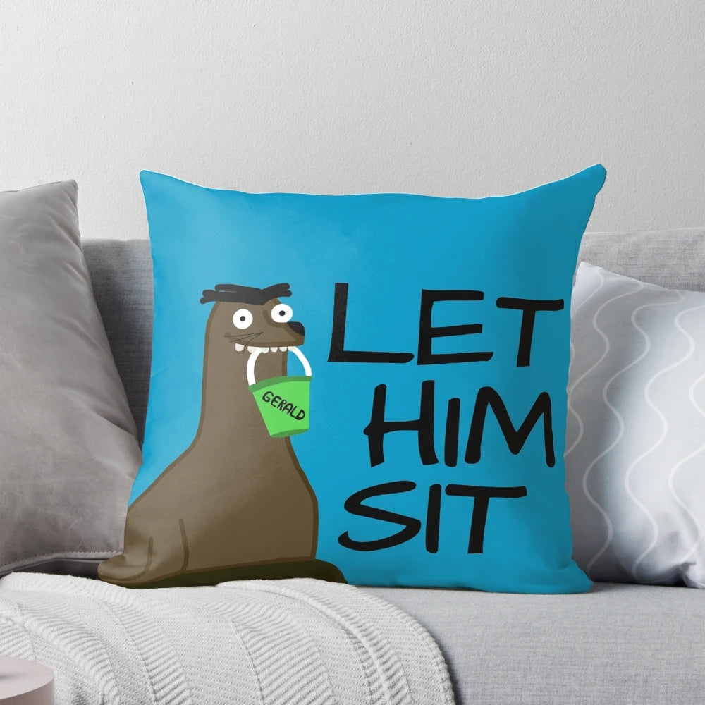 Photograph of a plush, decorative pillow shaped like a sea lion, with the text "Let Gerald Sit" printed on it.