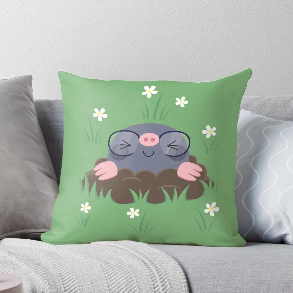 A decorative pillow featuring a pattern of cute, cartoon-style moles wearing eyeglasses and surrounded by grass and white flowers.