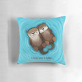 Two otters holding hands on a soft, plush pillow