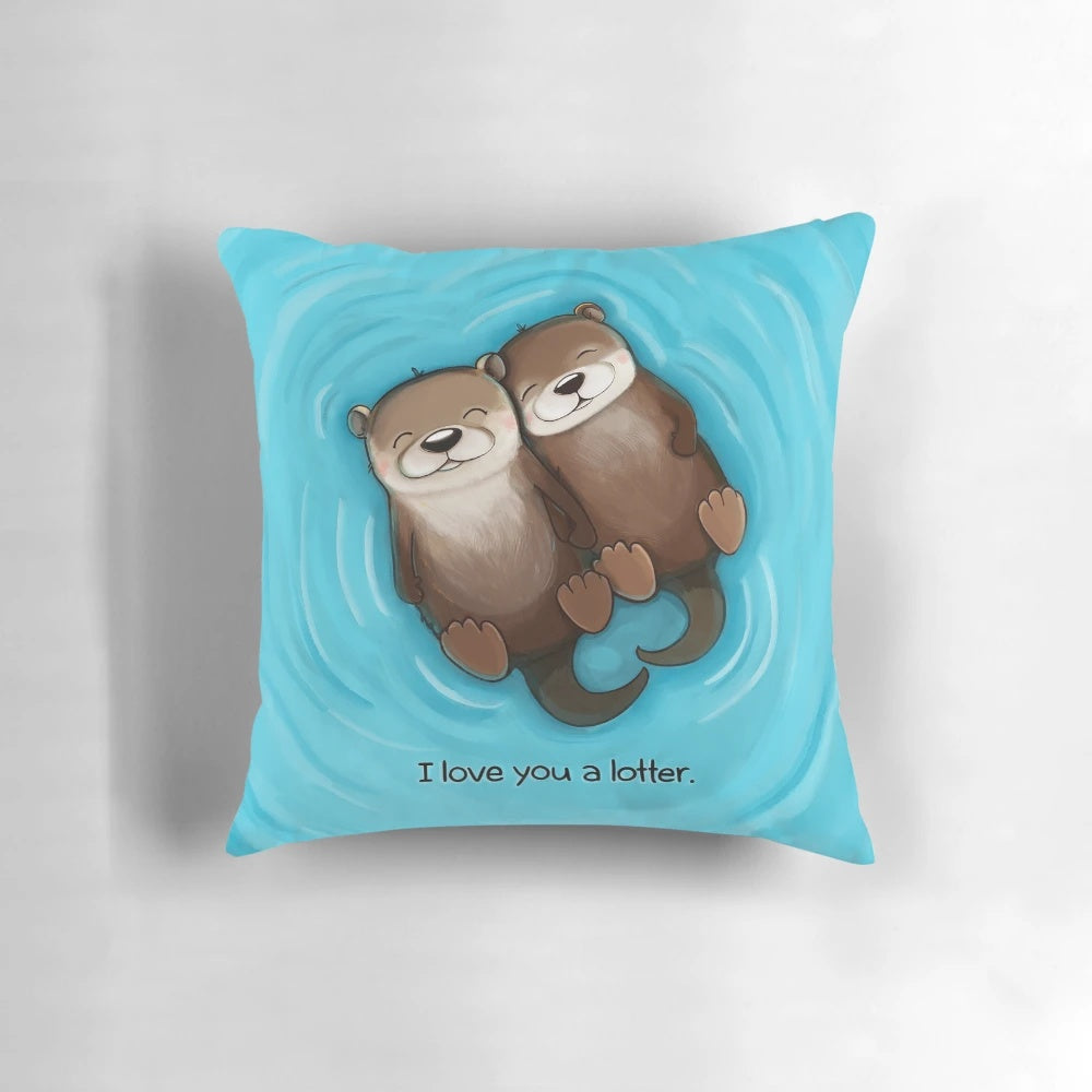 Two otters holding hands on a soft, plush pillow