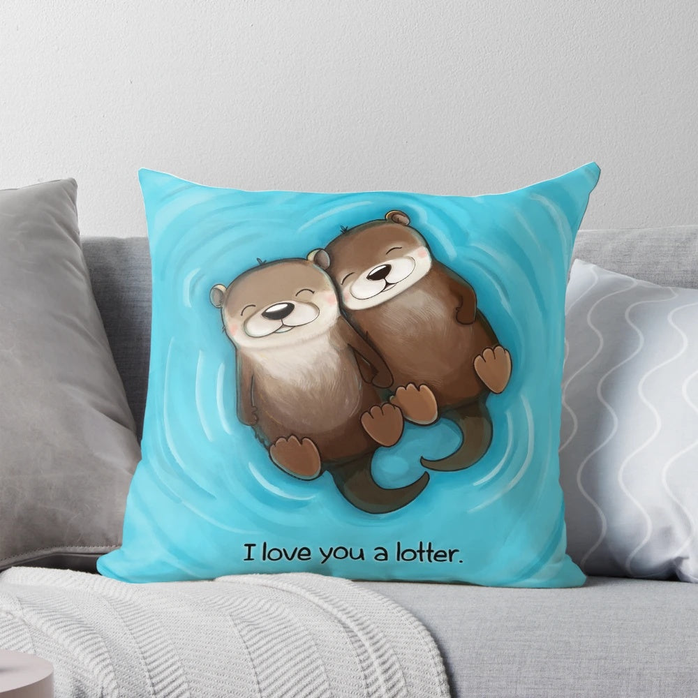 Two otters holding hands on a soft, plush pillow