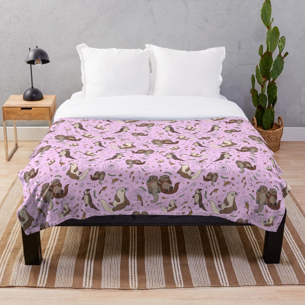 Cozy pink plush blanket featuring a cute otter design