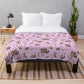 Cozy pink plush blanket featuring a cute otter design