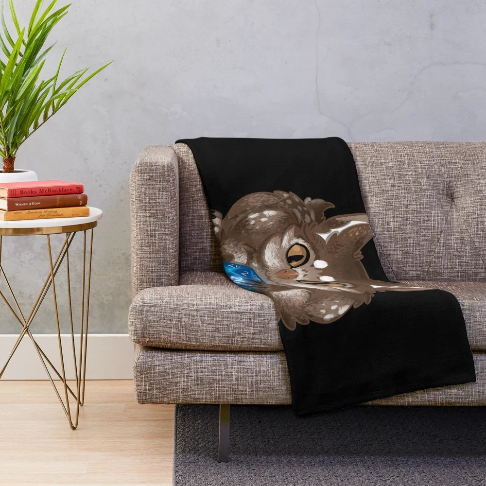 Soft and cuddly plush owlbear creature on a cozy blanket