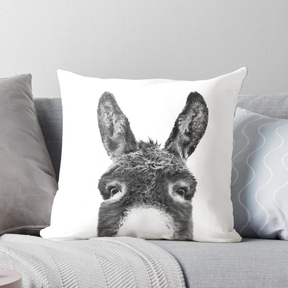 Soft, black and white pillow with a playful donkey peeking out