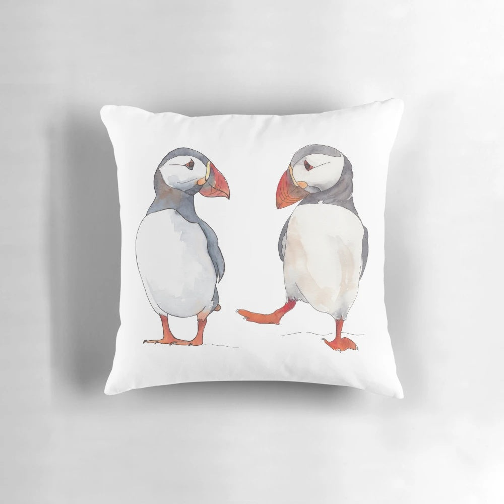 Soft, cozy pillow featuring illustrated puffins dancing and playing in the ocean
