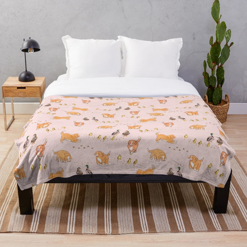 Soft pink plush blanket featuring cute cartoon illustrations of Nova Scotia duck tolling retriever puppies and mallard ducklings