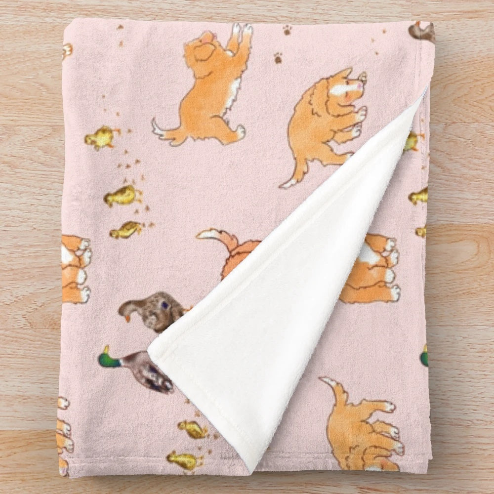 Soft pink plush blanket featuring cute cartoon illustrations of Nova Scotia duck tolling retriever puppies and mallard ducklings