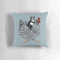 Tuxedo cat sitting on a chicken-shaped pillow, a humorous and cute home decor item.