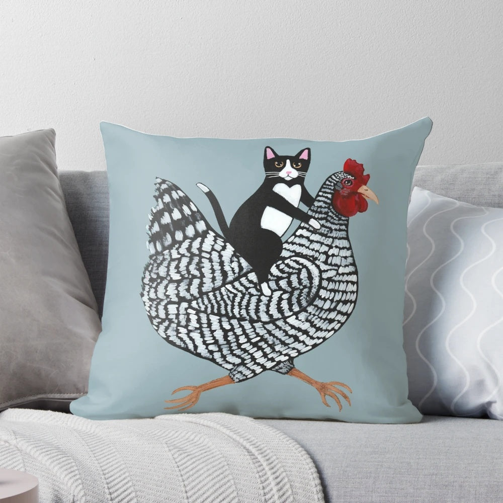 Tuxedo cat sitting on a chicken-shaped pillow, a humorous and cute home decor item.