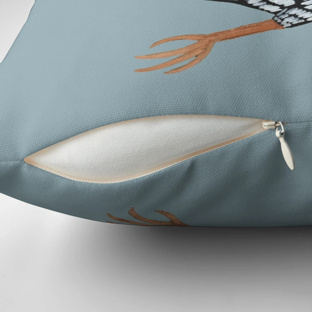Tuxedo cat sitting on a chicken-shaped pillow, a humorous and cute home decor item.