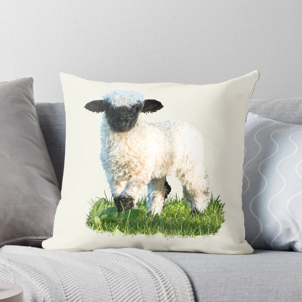 A soft, plush pillow featuring an adorable Valais Blacknose sheep lamb in a beautiful natural meadow setting.