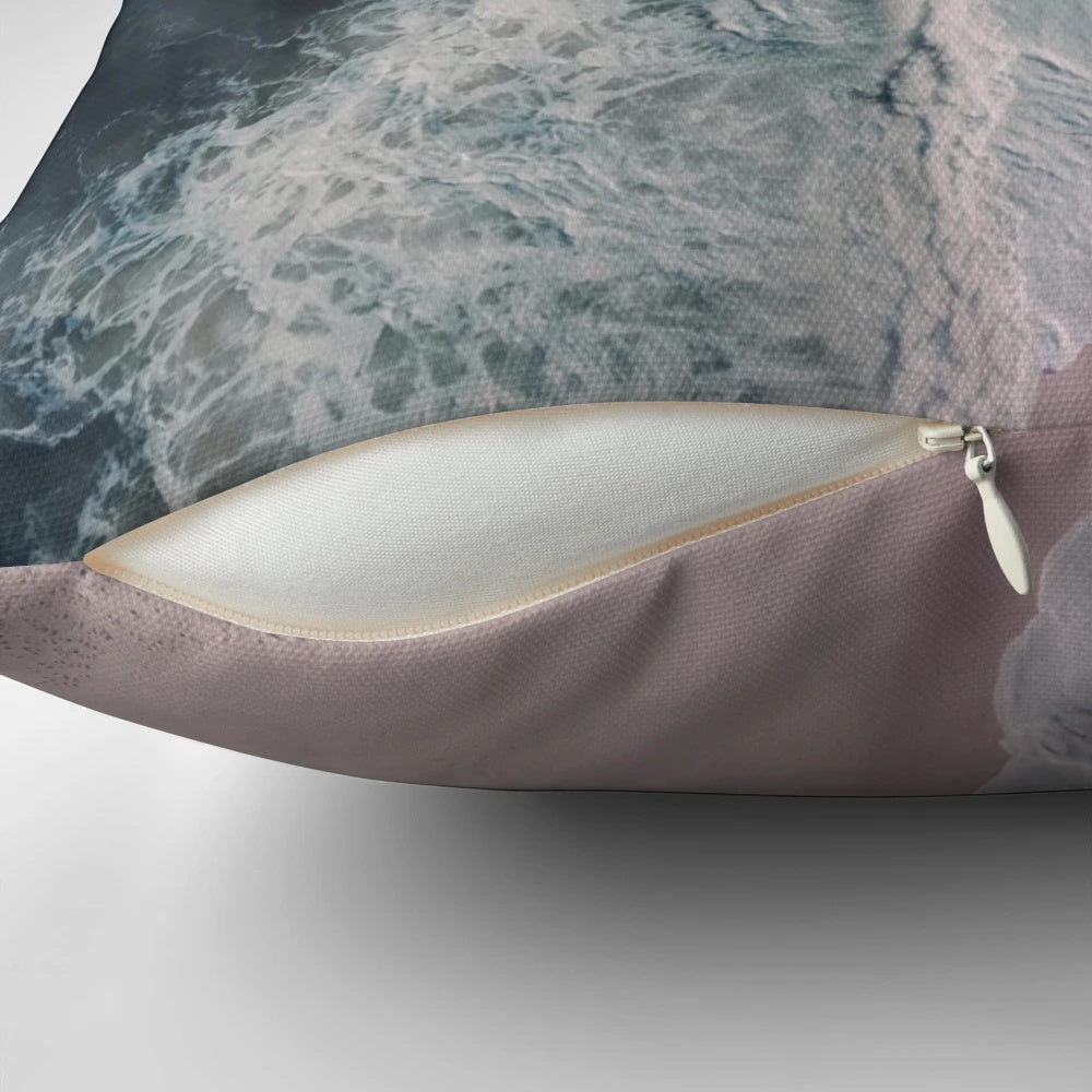 Aerial photograph of pink sand beach, crashing waves, and dark blue ocean